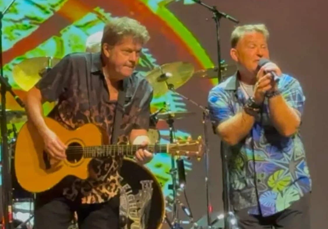 J.C. Grigg singing beside Keith Howland on acoustic guitar onstage