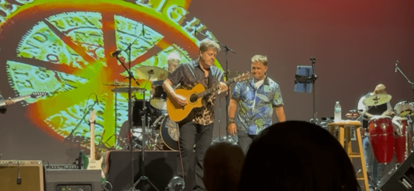 Keith Howland on acoustic guitar with JC Grigg on stage