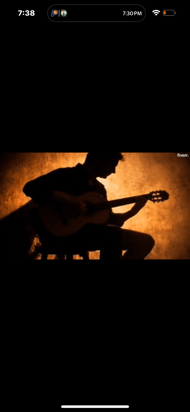 Musician silhouette with acoustic guitar against warm golden backdrop